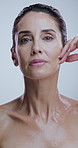 Skincare, hands and face of woman in studio for anti aging, cosmetics and wrinkle treatment. Dermatology, touch and portrait of mature person for beauty, spa and glow of natural texture on background