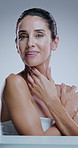 Mature woman, skincare and touch face in studio with results, smile and transformation by background. Person, model and beauty in portrait for cosmetics, change and benefits for anti aging in Italy