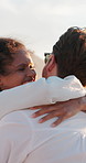 Love, couple and laughing with hug at beach for travel adventure, romantic vacation or funny conversation. People, embrace and bonding together by seaside for anniversary date or relationship support