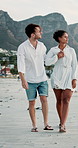 Beach, couple and walking with holding hands for travel, holiday and memory for valentines day. Ocean, man and woman with love embrace for healthy relationship, bonding and vacation for anniversary
