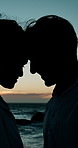 Beach, silhouette and couple with love by sunset, travel holiday and bonding together for anniversary. Ocean, woman and man with embrace for healthy relationship, commitment and admiration outdoor