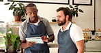 People, waiter and talking on tablet at cafe with training, online order and menu update on website. Men, discussion and digital with teamwork, inventory management and feedback on customer service