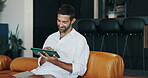 House, online and man with tablet, entertainment and funny videos in living room, smile and relax. Happy, chilling and person with tech for movies, laughing and browsing for comedy on app in home