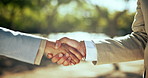 Business people, handshake and meeting with greeting for partnership, agreement or thank you at outdoor park. Closeup, employees or colleagues shaking hands with teamwork for deal, trust or support