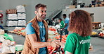 Happy people, volunteer or handshake with tablet for donation, charity help or assistance at NGO warehouse. Team, technology or shaking hands with smile for community service or social responsibility