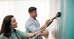 Couple, happy or painting a wall in home for diy renovation, living room makeover or house improvement. Interior design, people or support with lounge decoration process, conversation or relationship