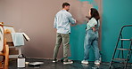 Painting, back and wall with couple in new house for  interior design, color choice or decor. Home improvement, property and support with woman and man in apartment for diy planning and real estate