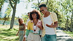 Happy people, walking and talking with fashion at park for holiday, weekend or bonding together in nature. Group, friends or strolling with smile for social, chat ot conversation on outdoor path