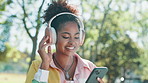 Nature, happy and woman with headphones and phone outdoor in park listening to music online. Travel, cellphone and female person streaming playlist, album or radio on app with audio tech in garden.