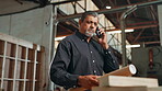 Architect, serious discussion and man with phone call in warehouse for construction issue and client feedback. Mature person, blueprint or talking to contractor for renovation project and development