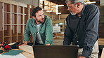 Teamwork, carpentry or people with laptop in warehouse for manufacturing, workshop or furniture production. Mentor, carpentry apprentice and online update for timber, lumber and construction business