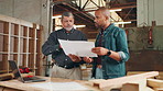 Carpentry, workshop and men with blueprints for woodwork, furniture restoration and teamwork. Construction, factory and man and contractor in discussion or meeting for timber, lumber or manufacturing