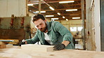 Carpentry, woodworking and man in workshop with dust on wood for furniture, manufacturing and lumber production. Construction, air compressor and carpenter with planks, timber or board for renovation