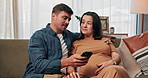 Pregnancy, home and couple on sofa with phone for online website, prenatal app and research parenting advice. Family, love and man with pregnant woman on smartphone for bonding, relax and talking