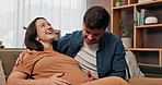 Laugh, pregnancy and happy couple on sofa with hands on stomach for support, care and conversation at home. Maternity, future or people in living room with growth, hug and child development together