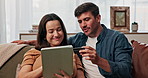 Tablet, credit card and payment with couple on sofa for online shopping, purchase and banking app. Fintech, ecommerce and savings with man and woman in living room at home for debit transaction
