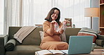 Baby clothes, laptop and video call with pregnant woman on sofa in living room of home for communication. Computer, smile and socks with happy mother in apartment to show newborn clothing purchase