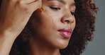 African woman, dropper and oil in studio for beauty, skincare and moisturizer with change by background. Girl, person and serum with natural cosmetics, transformation and dermatology with afro