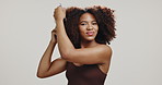 Comb, hair and face of black woman in studio for wellness, healthy texture and natural growth. Hairdresser, salon and portrait of person with confidence, beauty and curly style on white background