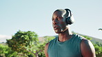 Black man, fitness and headphones with breathe for running, workout motivation or music at outdoor park. Active, male person or runner with earphones for sport, marathon or sprint challenge in city
