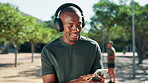 Black man, phone and fitness at park, headphones and happy for music, challenge or monitor progress in summer. African person, smartphone and streaming with audio, app or break for exercise in nature