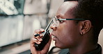 Security guard, radio and black man in control room, monitors and conversation for safety check. African person, employee and service with equipment, glasses and report with feedback and intercom