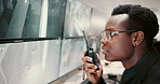 Security guard, radio and black man in control room, serious and protection for safety check. African person, employee and service with equipment, intercom system and report with feedback in office