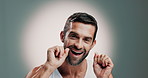 Oral health, face and man with floss in studio for cleaning, hygiene or morning mouth routine. Dental care, grooming and portrait of person with teeth string to prevent gum disease by gray background