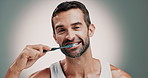 Dental care, face and man brushing teeth in studio for cleaning, hygiene or morning mouth routine. Oral health, plaque and portrait of person with toothbrush to prevent gum disease by gray background