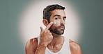 Skincare, face and man with face cream in studio for health, wellness and natural facial routine. Moisturizer, portrait and person with dermatology treatment with spf or sunscreen by gray background.