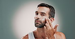 Skincare, natural and man with face cream in studio for health, wellness and facial routine. Moisturizer, portrait and person with dermatology treatment with spf or sunscreen by gray background.