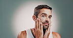 Skincare, beauty and man with face cream in studio for health, wellness and natural facial routine. Moisturizer, portrait and person with dermatology treatment with sunscreen by gray background.