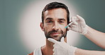 Hands, cosmetologist and man with facial injection in studio for skincare, antiaging and collagen. Cosmetic, needle and beautician with person for face transformation with filler by gray background.