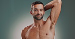 Armpit, hygiene and man in morning, smell and confident with routine for underarm, clean and studio. Grey background, face and person with smile for skincare, cosmetics and treatment for body odor