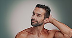 Model, man and face with hair care in studio, wellness or satisfaction with collagen treatment. Mockup space, male person or portrait with touching for cosmetics benefits, grooming or gray background