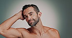 Studio, man and face with touch for hair care, wellness and satisfaction with collagen treatment. Mockup space, male person and portrait with smile for cosmetics benefits, grooming or gray background