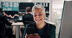 Computer, phone and smile with woman in trading office for communication or notification. App, good news and text message with mature broker or trader in finance workplace for portfolio management