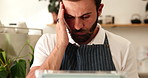Small business, man and barista with headache, stress or online service, social media or order at coffee shop. Tired, mental breakdown or espresso waiter with migraine or technology for cafe review