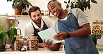 Cafe, colleagues and men with tablet, startup and planning for new menu, laughing and collaboration. Discussion, waiter and people with tech in coffee shop, hospitality and teamwork in small business