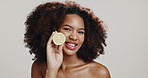 Skincare, beauty and face of woman with lemon in studio for dermatology on white background. Citrus fruit, natural cosmetics and happy African model with organic vitamin c, detox and healthy diet