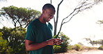 Happy, black man and fitness with phone in nature for social media, communication or sports app. Male person, African runner or smile with mobile smartphone for online chatting or texting in forest