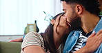 Love, happy couple and kiss in home, hug or bonding together with partner to relax. Romance, woman and man embrace on sofa for marriage, connection or commitment for healthy relationship with support