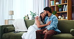 Love, couple and kiss on sofa, hug or bonding together with partner to relax. Romance, happy woman and man embrace in home for marriage, connection or commitment for healthy relationship with support