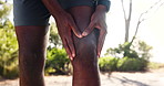 Hands, person and knee pain on road, exercise and rest for break, check and strain tendon in summer. Runner, outdoor and touch for joint injury in street with fitness, workout or training in Kenya
