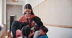 Happy, hugging and teacher with children at school for development, bonding and learning. Care, education and female educator embracing kid students for greeting with love at elementary academy.