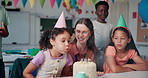Kids, clapping and blow cake for birthday party with teacher, friends and students at school. Children, candles and happy people at celebration, congratulations and special event with class together