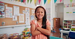 Smile, face and kid with crossed arms in classroom for learning, education or childhood development. Scholarship, portrait and girl student with confidence for back to school at elementary academy.
