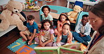 Book, learning and teacher reading to students in classroom of school for development or growth. Education, scholarship and storytelling with group of kids on academy floor for literature lesson