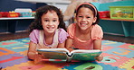 Education, classroom and face of children with book for learning, development or story time. Happy, friends and girl students reading novel on floor for literacy knowledge at elementary school. 
