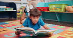 Kid, student and reading book in school, learning english and language development at academy. Boy, education and fantasy storytelling for vocabulary growth in class, fiction and person studying